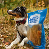 A dog sits next to a bag of Best Bully Sticks 100% All-Natural Cow Ears (20 Pack).