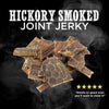 A pile of Best Bully Sticks Hickory Smoked Beef Jerky Gullet Bites sits on a dark smoky background with five stars and the quote, &quot;Smells so good even you&#39;ll want to chew it!&quot;—a tasty treat for rewarding your pup.