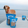 A dog is standing on a dock next to bags of Best Bully Sticks Beef Trachea Dog Chews - 5 to 6 Inch.