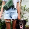 A woman wearing shorts and a green The BEST Neoprene Fanny + Crossbody - Green from Best Bully Sticks with a black dog.